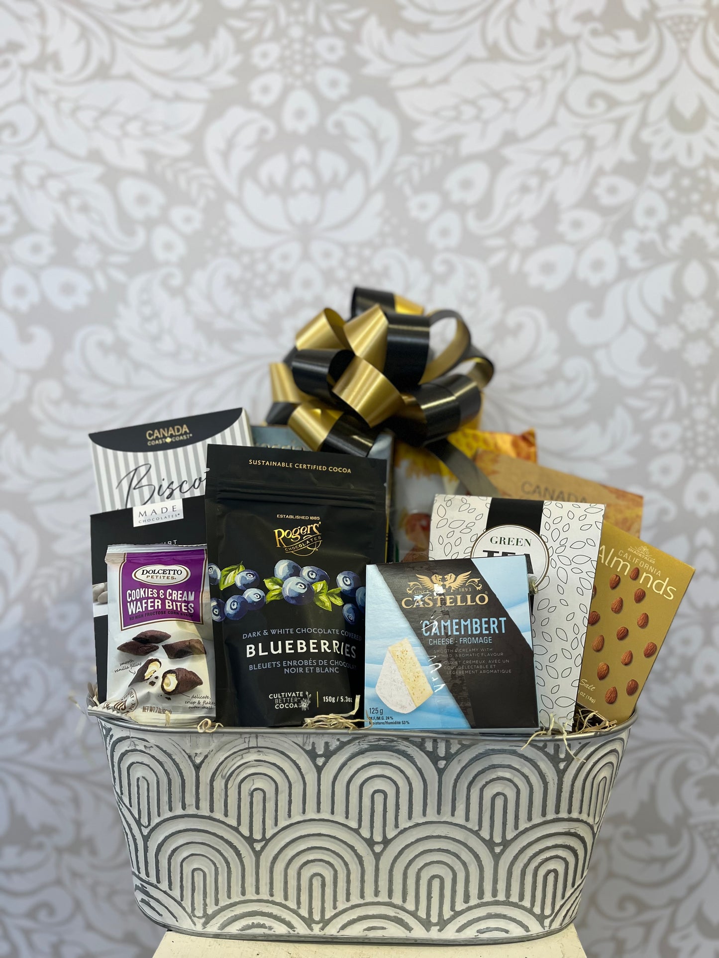 Feels Like Home Gift Basket in a keepsake planter with tea, biscotti, chocolates, crackers and sweet treats